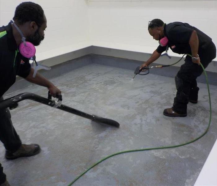 Two of our production team members spraying the floor